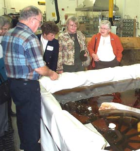 ASM members examine the conservation tanks as Howard Wellman explains their 
        use