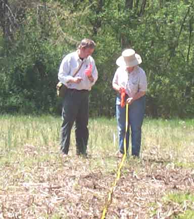 Team members use tape measures and compasses to lay out a grid with 20 meter intervals.